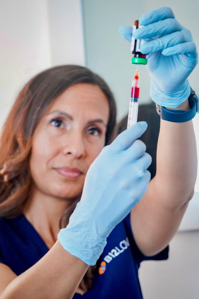 woman in surgical gloves with a syringe